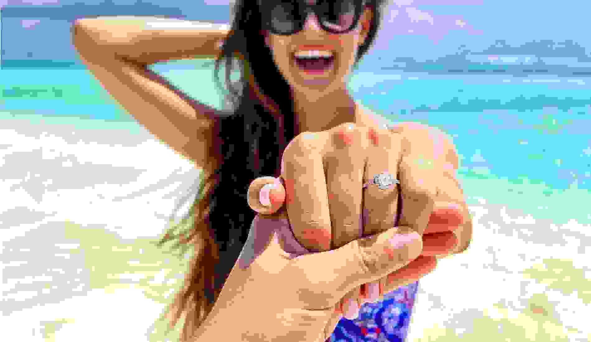 Engagment ring on womans hand on a beach