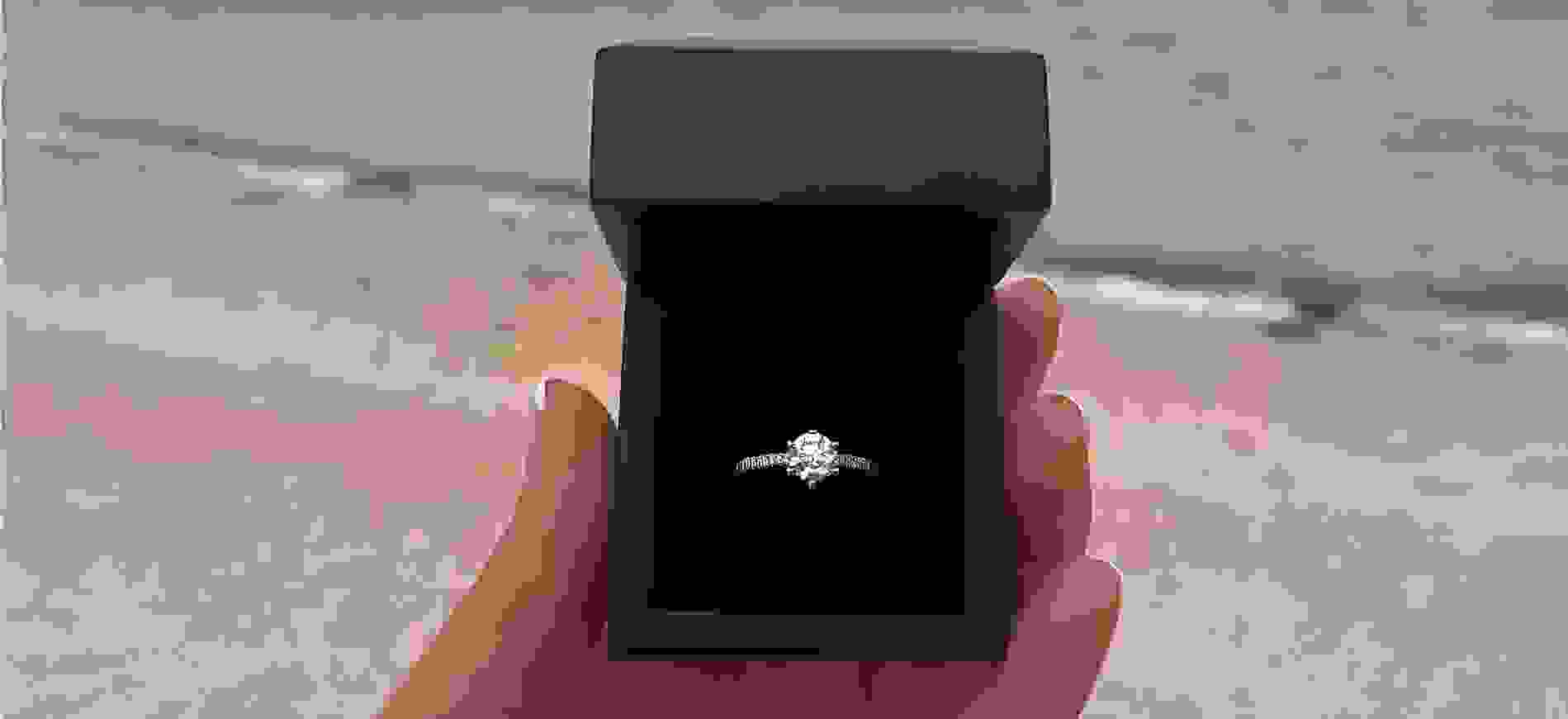 Engagement ring in a box on a beach