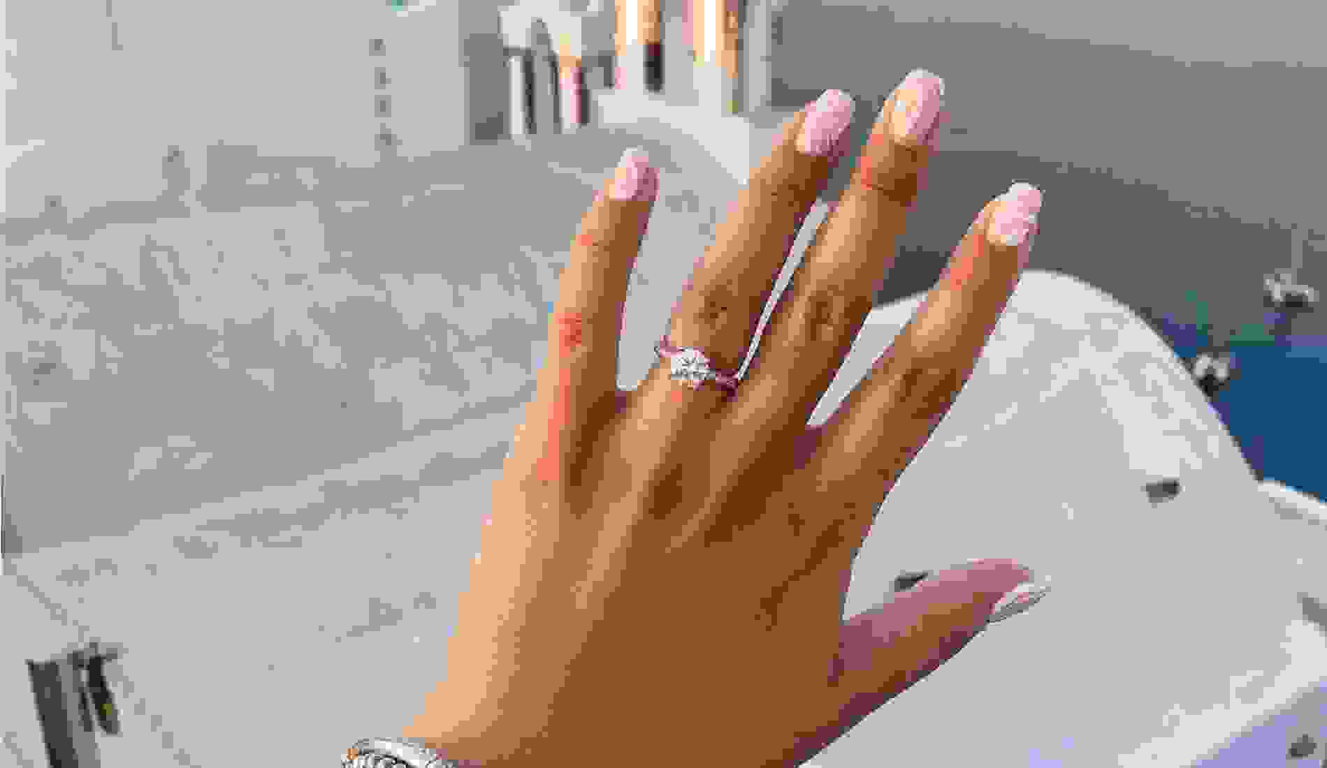 Engagement ring up close with a costal scene in the backgorund