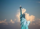 Statue of Liberty holding a torch against a dramatic cloudy sky, symbolizing freedom in New York City