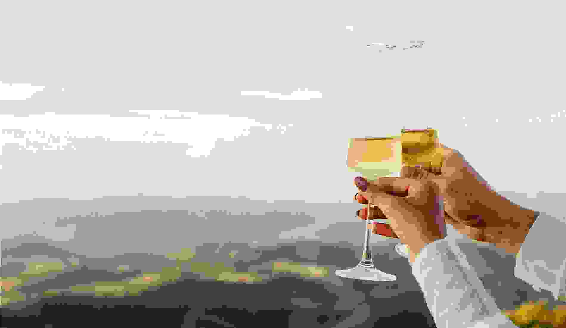 Close-up of a couple clinking champagne glasses with a scenic mountain landscape in the background, celebrating a romantic moment. .