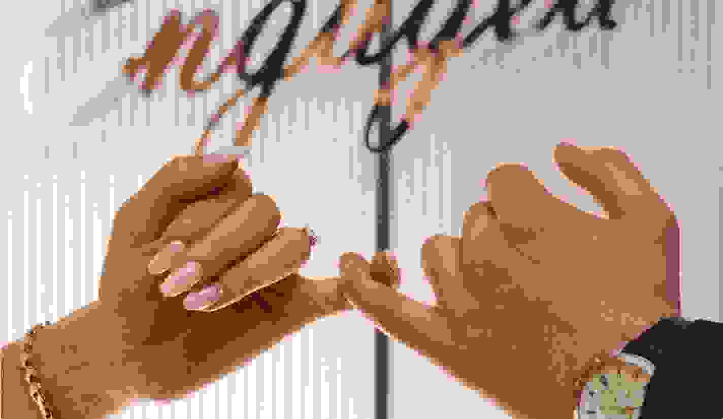 Close up of a pinkie promise of an engaged couple