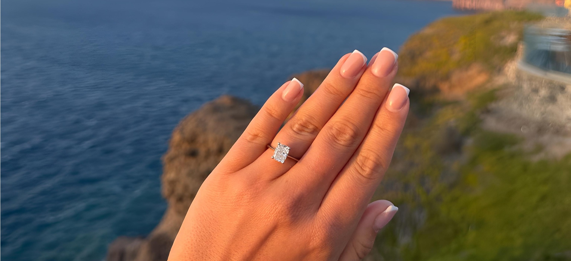 Engagement ring up close with a costal scene in the backgorund