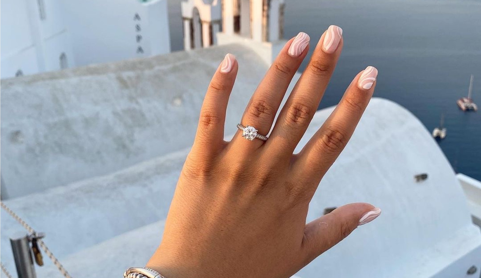 Engagement ring up close with a costal scene in the backgorund