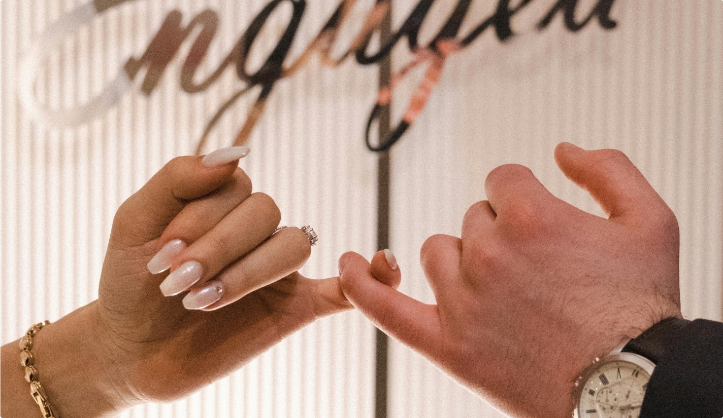 Close up of a pinkie promise of an engaged couple