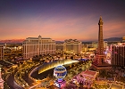 Colorful evening view of the Las Vegas Strip featuring bright lights, iconic hotels, and the Eiffel Tower replica