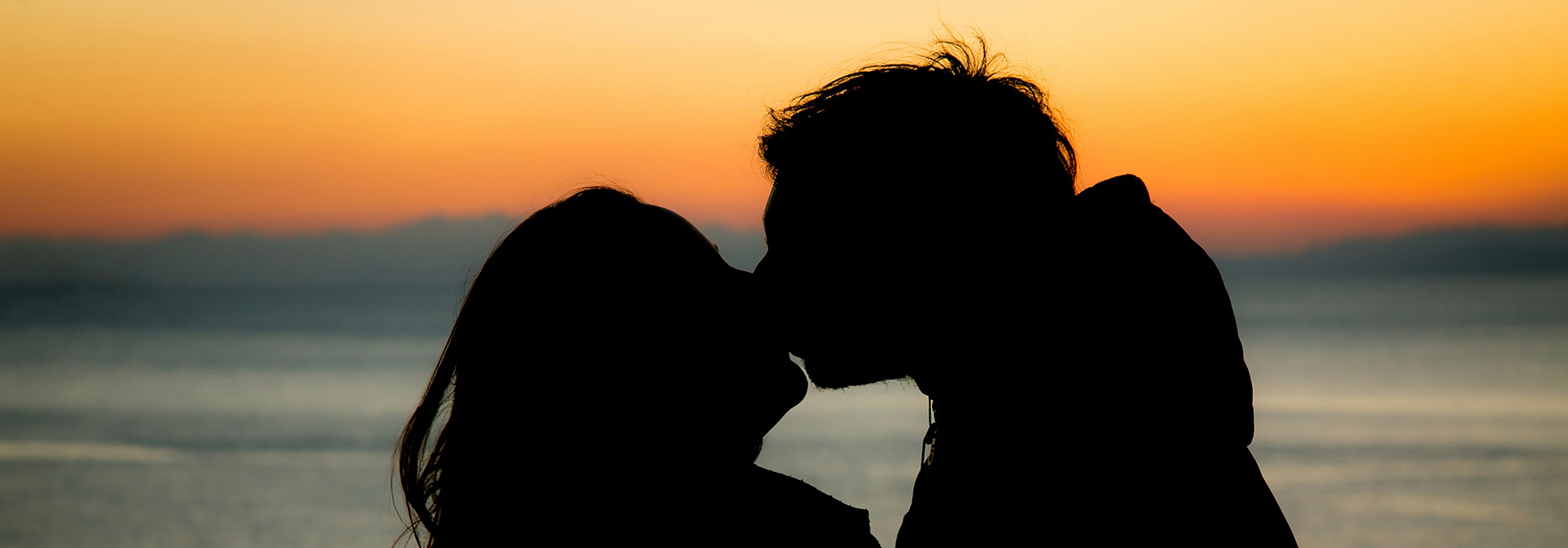Close-up of a person working on a laptop next to another open laptop, suggesting online activity or browsing.