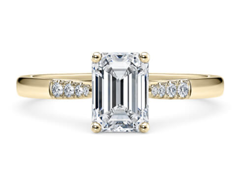 Thea in Oro Amarillo set with a Esmeralda cut diamante.